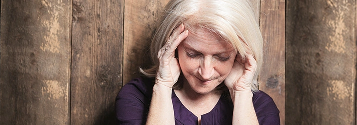 Person with hands on head, indicating possible headache.