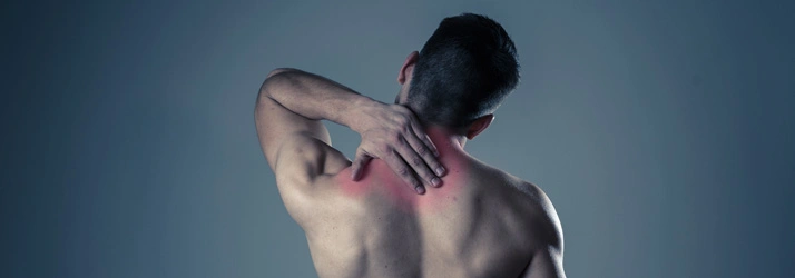 Person holding the back of the neck with visible redness.