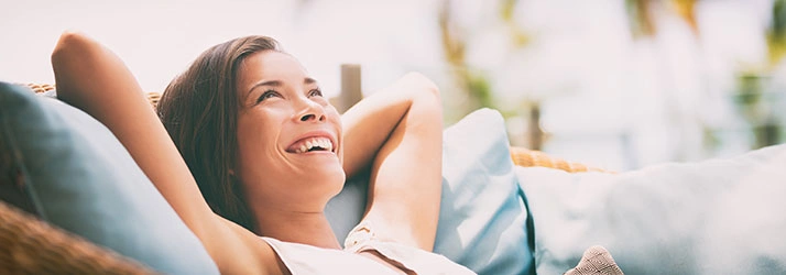 Person reclining on a couch outdoors in a relaxed position.