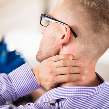 Person holding the back of the neck, indicating discomfort.